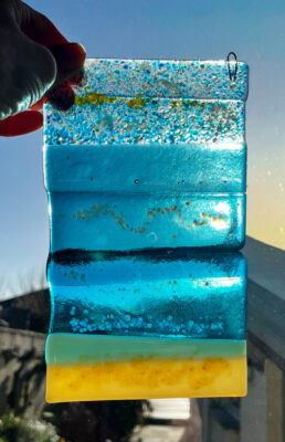 Handgemaakte zonnevanger vervaardigd uit verschillende lagen kleurrijk glas.